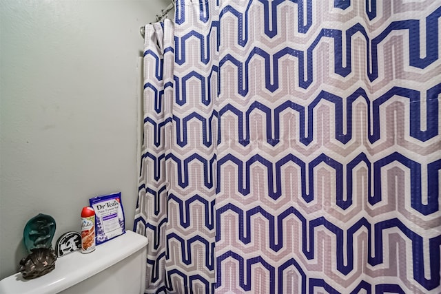 bathroom with a shower with curtain and toilet