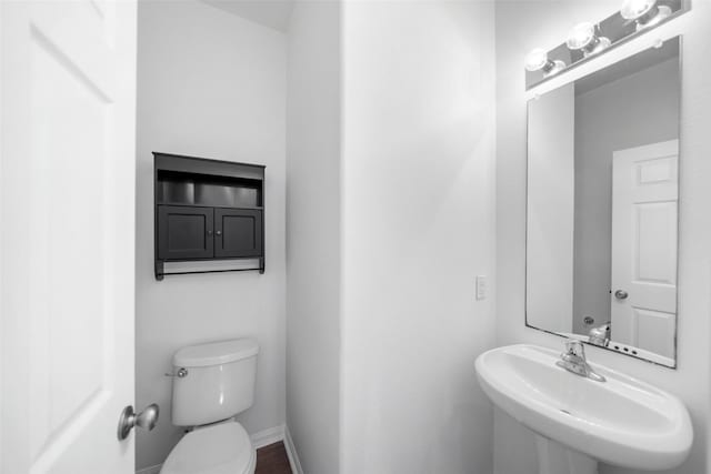 bathroom with sink, hardwood / wood-style floors, and toilet