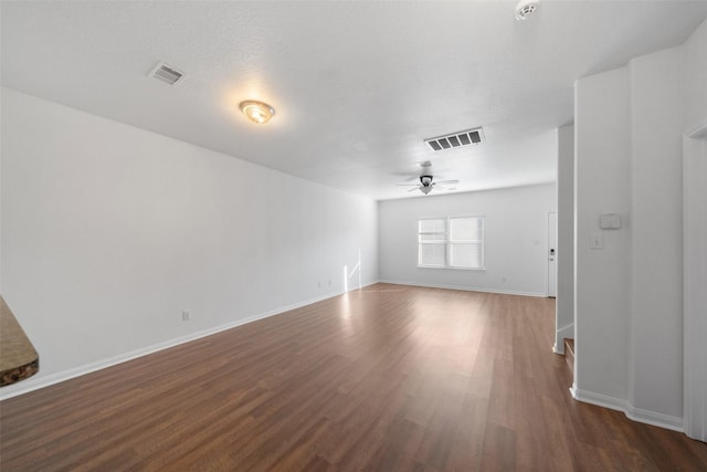 spare room featuring ceiling fan and dark wood-type flooring