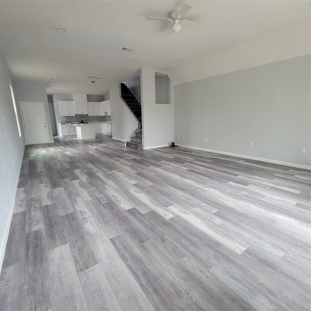 unfurnished living room with ceiling fan and light wood-type flooring