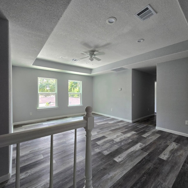 6232 Nuben St, Houston, TX 77091 - unfurnished room with a textured ceiling, ceiling fan, wood finished floors, and a raised ceiling