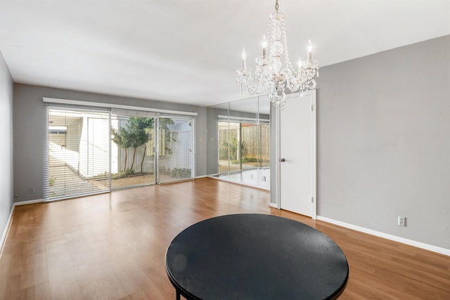 dining area featuring wood-type flooring and an inviting chandelier