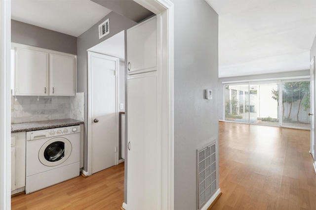 laundry area with light hardwood / wood-style floors, cabinets, and washer / clothes dryer