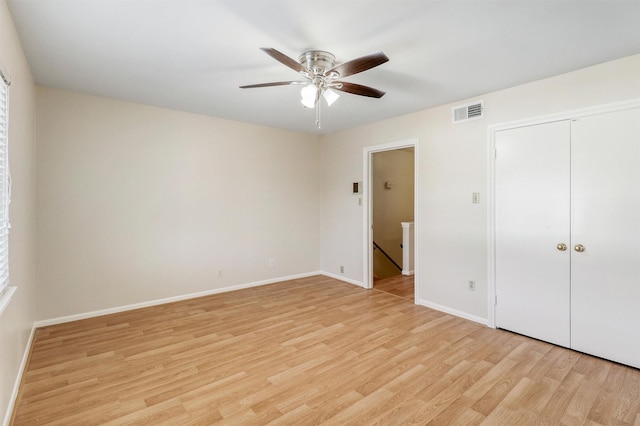 unfurnished bedroom featuring ceiling fan, a closet, and light wood-type flooring