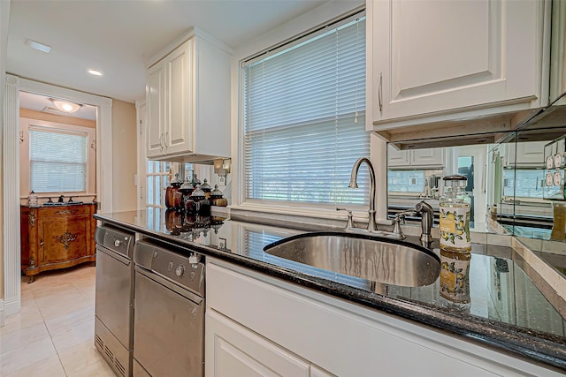 kitchen with white cabinetry, light tile patterned flooring, sink, and dark stone countertops