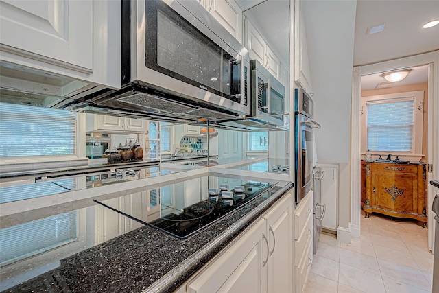 614 Clear Lake Rd, Kemah, TX 77565 - kitchen with stainless steel appliances, white cabinets, light tile patterned floors, and healthy amount of natural light