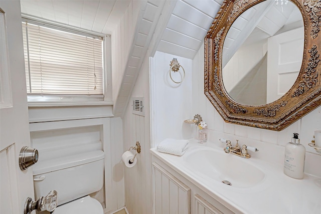 bathroom featuring lofted ceiling, toilet, and vanity