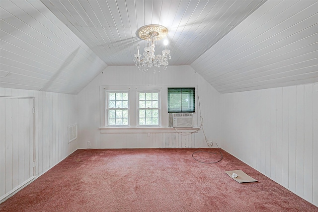 additional living space featuring carpet floors, a notable chandelier, and wooden walls