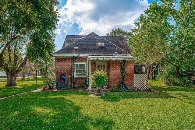 614 Clear Lake Rd, Kemah, TX 77565 - view of front of home with a front lawn, brick siding, a shingled roof, and an outbuilding