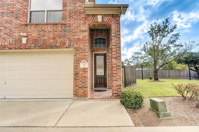 doorway to property featuring a lawn and a garage