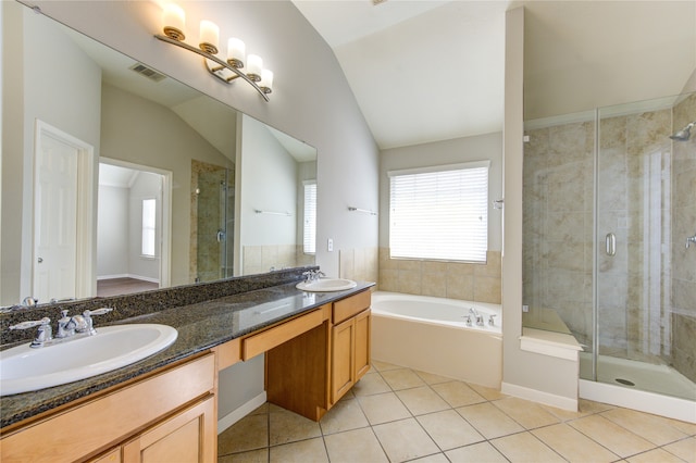 bathroom with tile patterned flooring, vanity, a healthy amount of sunlight, and lofted ceiling