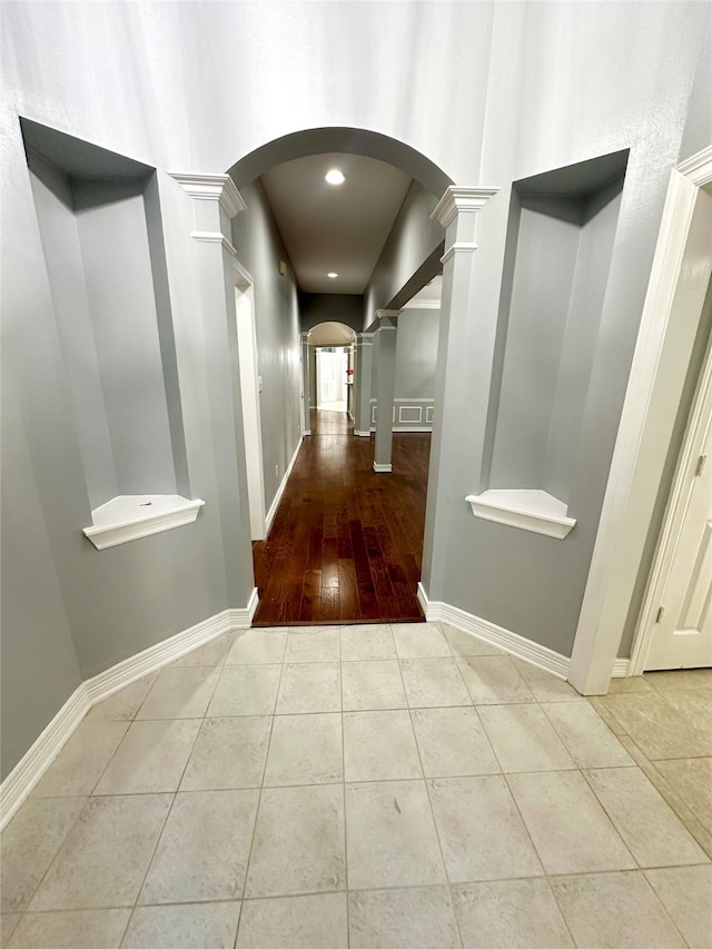 hall featuring hardwood / wood-style floors and ornate columns