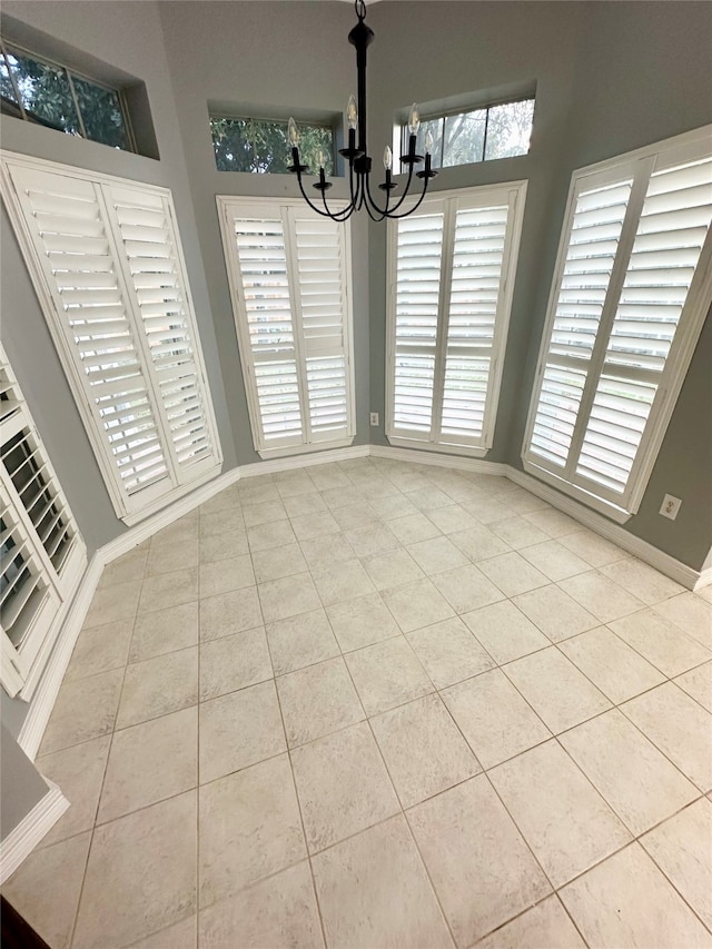 unfurnished dining area with light tile patterned floors and a chandelier