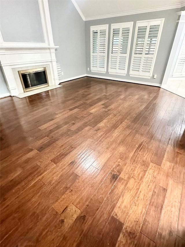 unfurnished living room with hardwood / wood-style flooring and crown molding