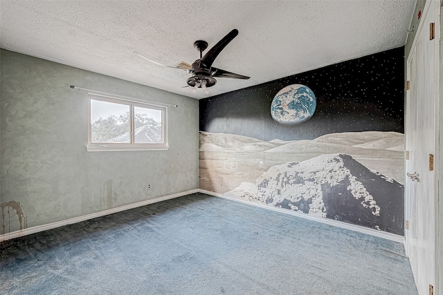 empty room featuring ceiling fan, carpet, and a textured ceiling