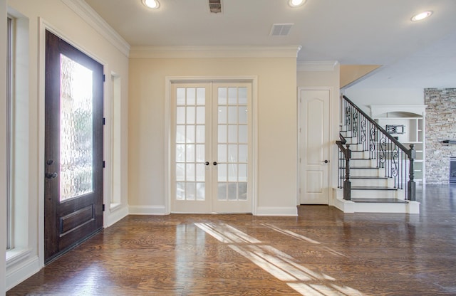 foyer entrance with dark hardwood / wood-style flooring, french doors, and ornamental molding