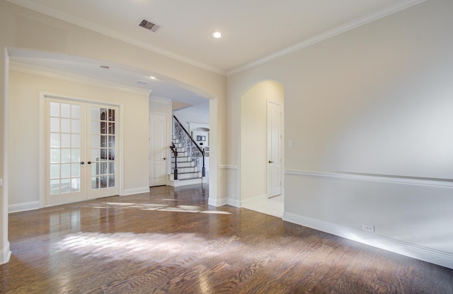 spare room featuring wood-type flooring, crown molding, and french doors