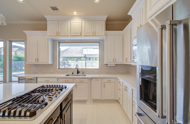 kitchen with white cabinets, plenty of natural light, sink, and appliances with stainless steel finishes