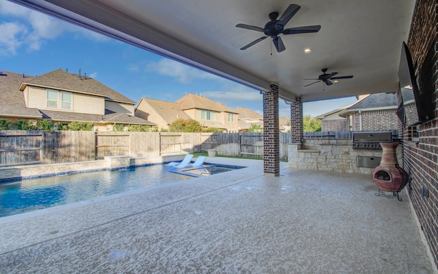 view of pool with pool water feature, ceiling fan, exterior kitchen, grilling area, and a patio area