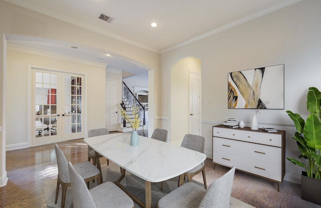 dining space featuring dark hardwood / wood-style flooring, ornamental molding, and french doors