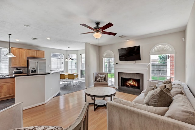 living room with ceiling fan and light hardwood / wood-style floors