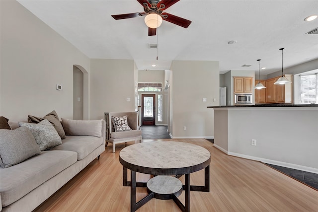 living room featuring light wood-type flooring and ceiling fan