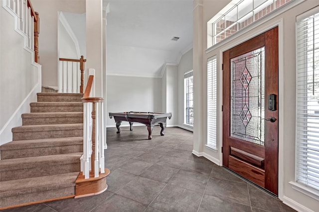 entrance foyer featuring tile patterned floors, vaulted ceiling, crown molding, and billiards