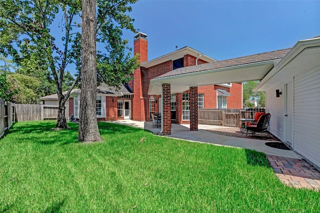 rear view of property with a patio area and a lawn