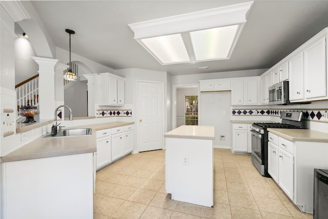 kitchen with white cabinets, decorative backsplash, stainless steel appliances, and hanging light fixtures