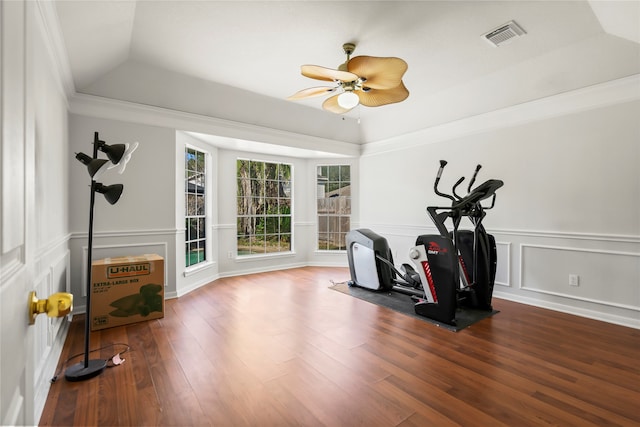 workout room featuring hardwood / wood-style flooring, a raised ceiling, ceiling fan, and ornamental molding