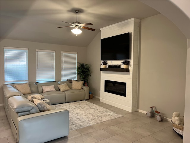 tiled living room with ceiling fan, lofted ceiling, and a fireplace