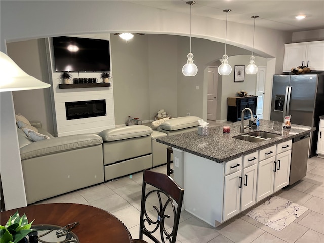 kitchen with white cabinetry, sink, hanging light fixtures, a kitchen island with sink, and appliances with stainless steel finishes