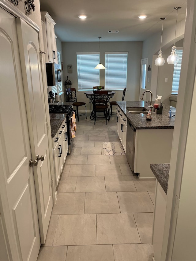 kitchen with white cabinetry, sink, hanging light fixtures, and stainless steel appliances