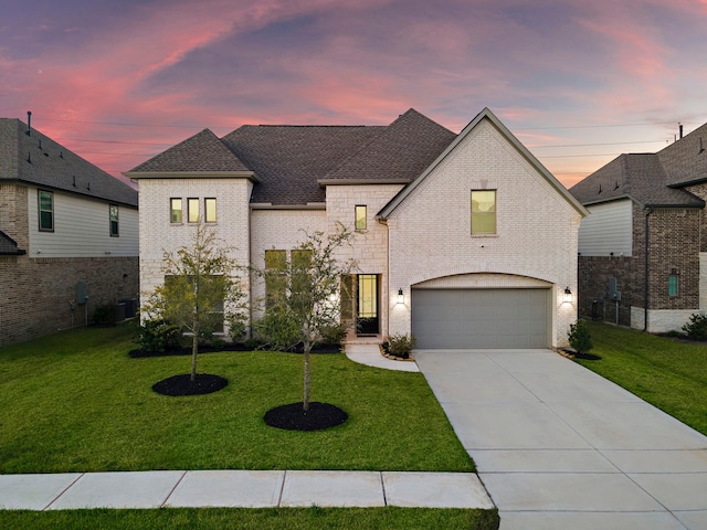 french country inspired facade featuring a garage and a lawn