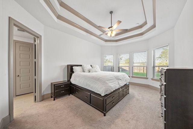 bedroom featuring a raised ceiling, ceiling fan, light colored carpet, and ornamental molding