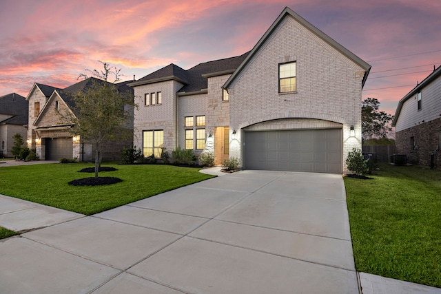 french country inspired facade featuring a lawn, a garage, and central AC