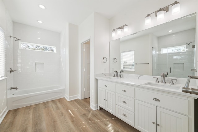 bathroom with tiled shower / bath, vanity, and hardwood / wood-style flooring