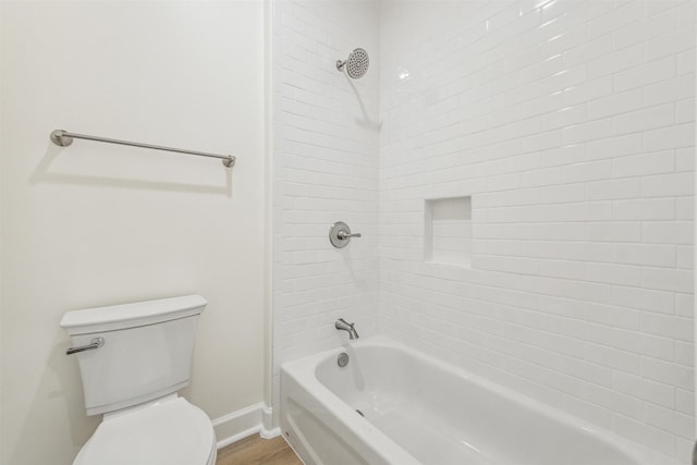 bathroom featuring hardwood / wood-style floors, tiled shower / bath combo, and toilet