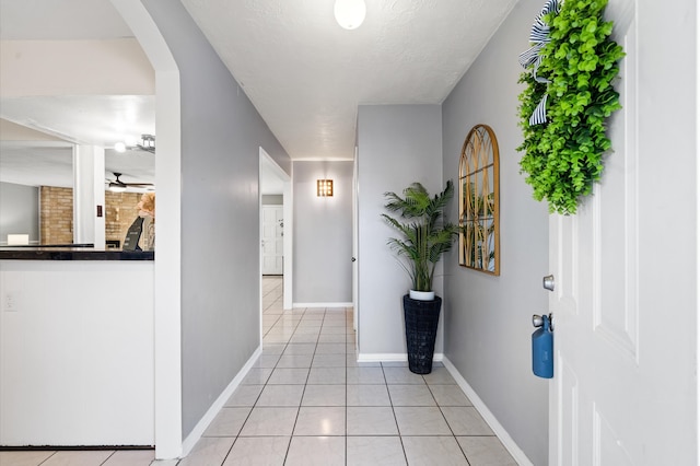 hallway featuring light tile patterned flooring and a textured ceiling