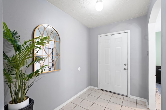 tiled entryway featuring a textured ceiling