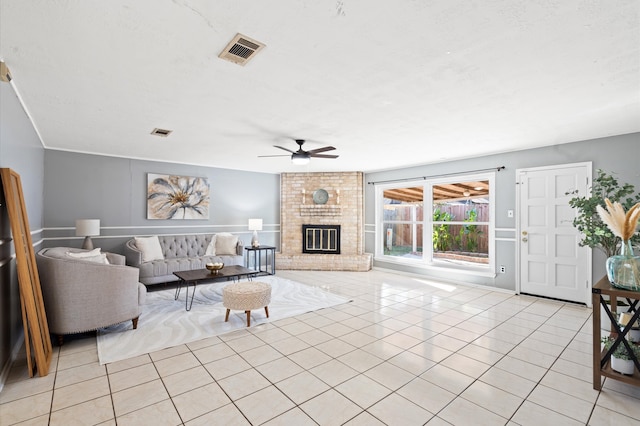 living room with ceiling fan, a fireplace, and light tile patterned floors