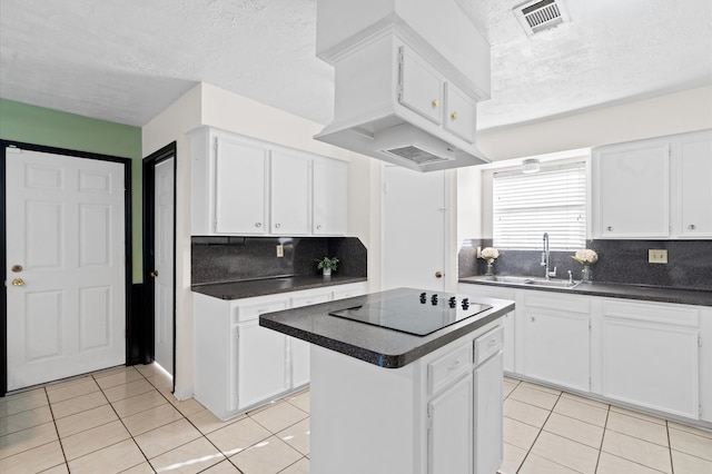 kitchen featuring tasteful backsplash, white cabinetry, sink, and a kitchen island