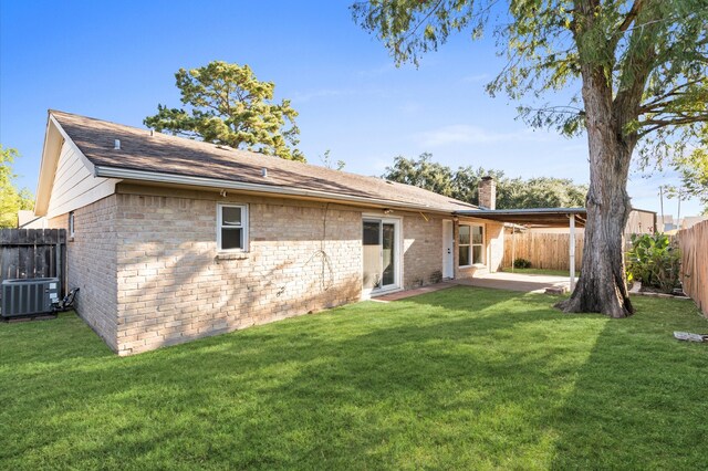 back of house with cooling unit, a yard, and a patio