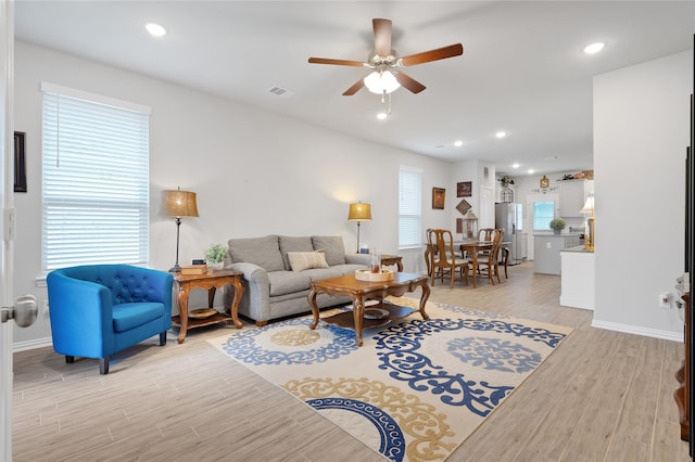 living room with ceiling fan and light hardwood / wood-style flooring