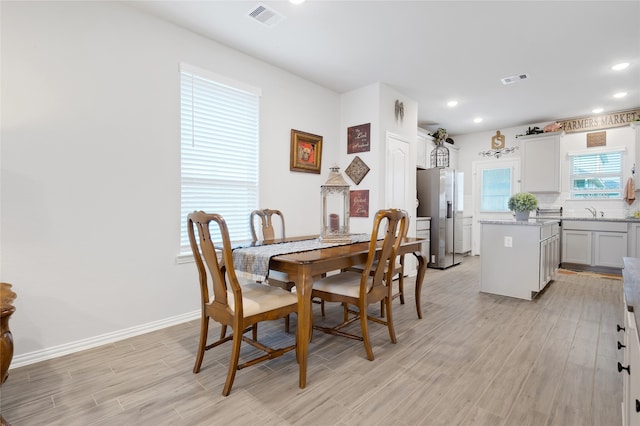 dining room featuring light wood-type flooring and sink