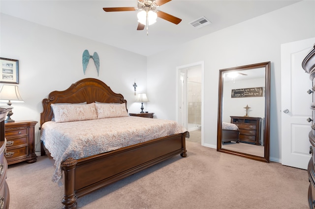 bedroom featuring ceiling fan, light colored carpet, and connected bathroom