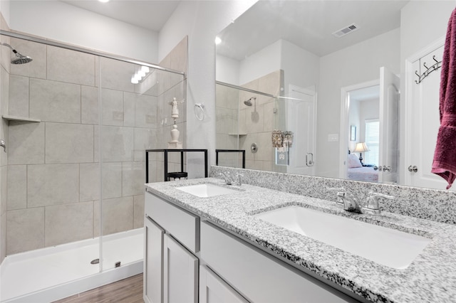 bathroom with hardwood / wood-style floors, vanity, and a shower with door