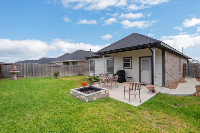 rear view of house featuring a fire pit, a patio, and a lawn