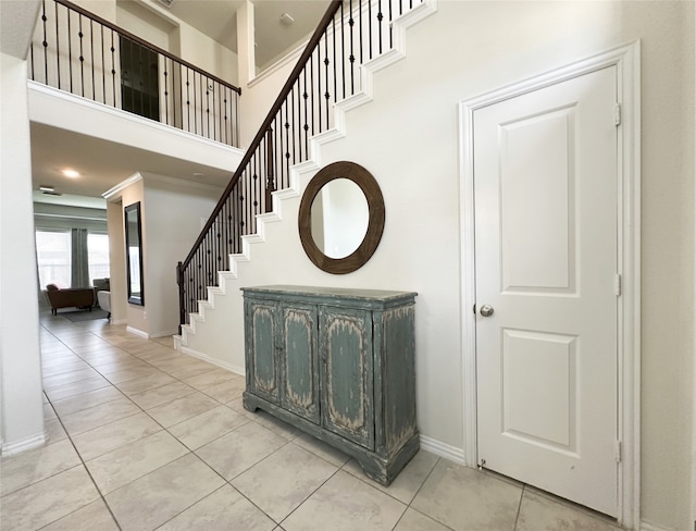 stairway featuring a high ceiling and tile patterned floors