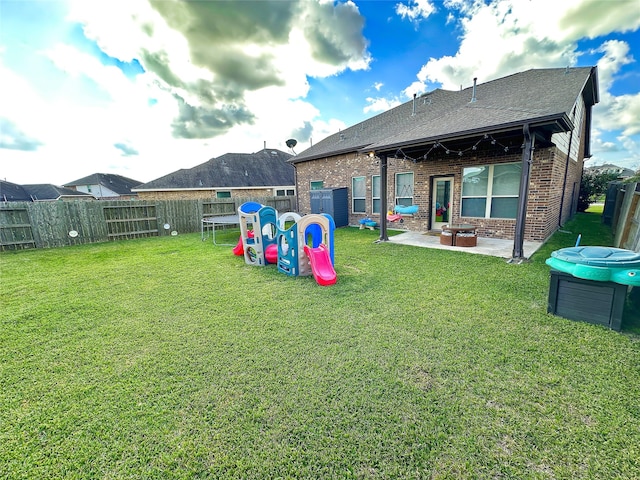 back of property with a lawn, a playground, and a patio